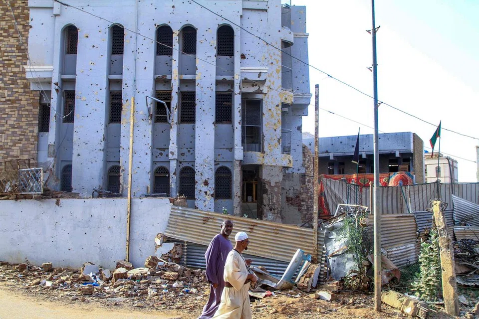 Lelaki Sudan berjalan melewati sebuah bangunan yang dipenuhi kesan peluru di bandar kembar Khartoum, Omdurman, pada 20 Mac 2025. Sejak April 2023, konflik ini melibatkan ketua tentera Abdel Fattah al-Burhan menentang bekas timbalannya yang kini merupakan komander RSF, Mohamed Hamdan Daglo. Pertempuran tersebut telah mengorbankan ribuan nyawa dan menyebabkan lebih 12 juta orang kehilangan tempat tinggal, menurut angka Pertubuhan Bangsa-Bangsa Bersatu (PBB), dengan ramai tinggal di kem sementara dan lebih 3.5 juta melarikan diri ke luar sempadan negara. 