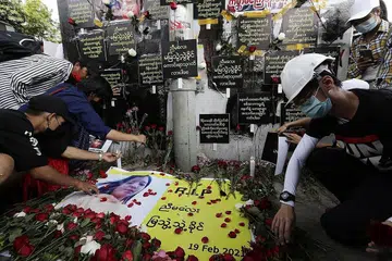 PEMBANTAH DIRUNDUNG HIBA: Warga Myanmar yang tunjuk perasaan mengenang pemergian pembantah belia, Cik Mya Thwe Thwe Khaing, 20 tahun, dengan menyumbang bunga dan membakar lilin di Yangon semalam. - Foto EPA-EFE