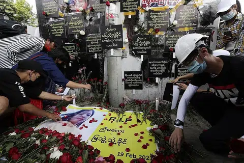 PEMBANTAH DIRUNDUNG HIBA: Warga Myanmar yang tunjuk perasaan mengenang pemergian pembantah belia, Cik Mya Thwe Thwe Khaing, 20 tahun, dengan menyumbang bunga dan membakar lilin di Yangon semalam. - Foto EPA-EFE