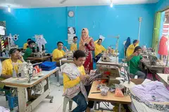 MENGUBAH STRATEGI: Pemilik Ilham Empire, Cik Nur Asyiqin Jumato (berdiri), bergambar bersama tukang jahitnya di sebuah kilang di sekitar kawasan Batam Centre, Batam, Indonesia. Beliau akan menjual bekalan pakaiannya di gerai yang disewanya di pusat beli-belah Causeway Point. - Foto-foto ILHAM EMPIRE
