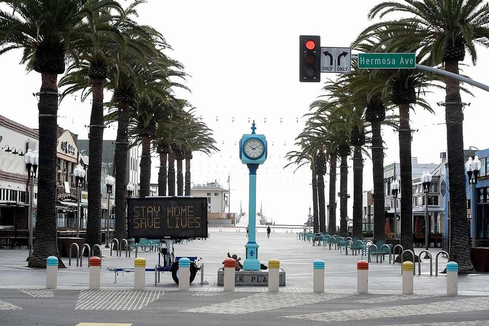 PERINGATAN: Terdapat papan tanda di kawasan Pantai Hermosa, California, mengingatkan orang ramai supaya duduk di rumah untuk mencegah penularan Covid-19. - Foto AFP 