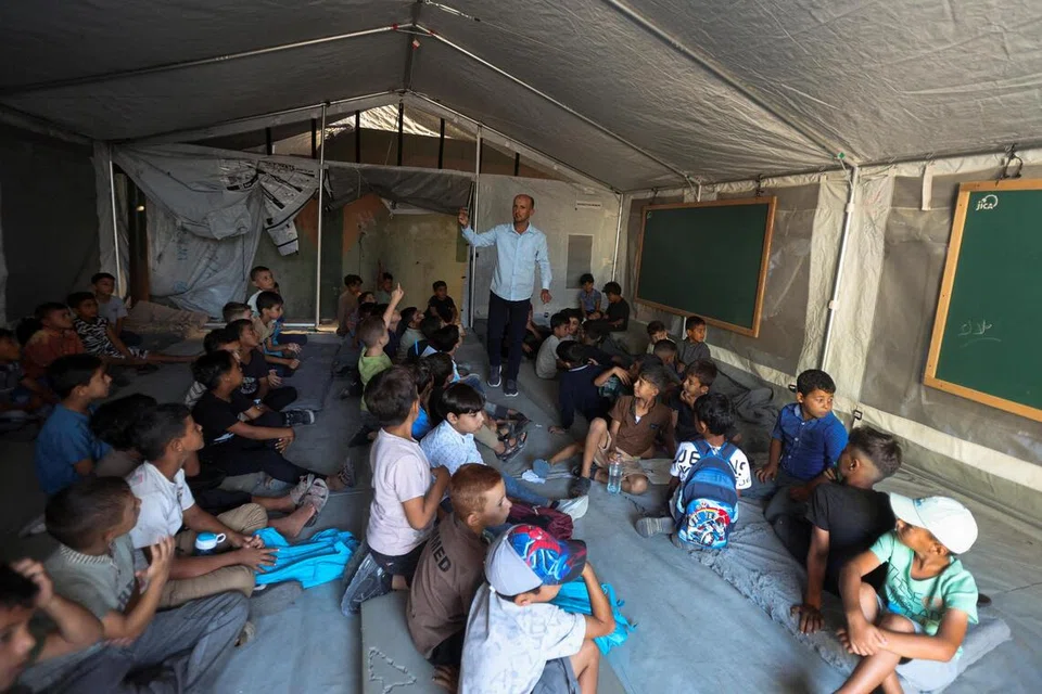 Para pelajar Gaza menghadiri hari pertama tahun persekolahan baharu di dalam bilik darjah khemah di sebuah sekolah di Khan Younis, selatan Jaluran Gaza, pada 19 September.