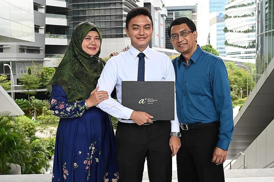 KEBANGGAAN IBU BAPA: Encik Hamzah Kamaruddin yang menerima Biasiswa Possiswazah A*Star 2022 ditemani ibu bapanya, Cik Selina Mohammad Kassim dan Encik Kamaruddin Mohamad Said di majlis anugerah biasiswa tersebut yang diadakan di The Theatre @ Mediacorp semalam. - Foto BH oleh KHALID BABA