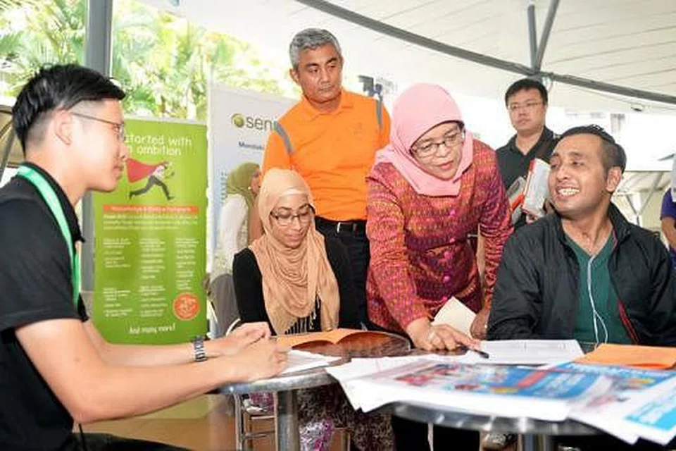 BANTU PENDUDUK DAPAT PEKERJAAN: Cik Halimah berharap ramai penduduk di sekitar kawasan Marsiling seperti Encik Azizur Rahman (kanan) mendapat pekerjaan yang sesuai. - Foto M.O.SALLEH