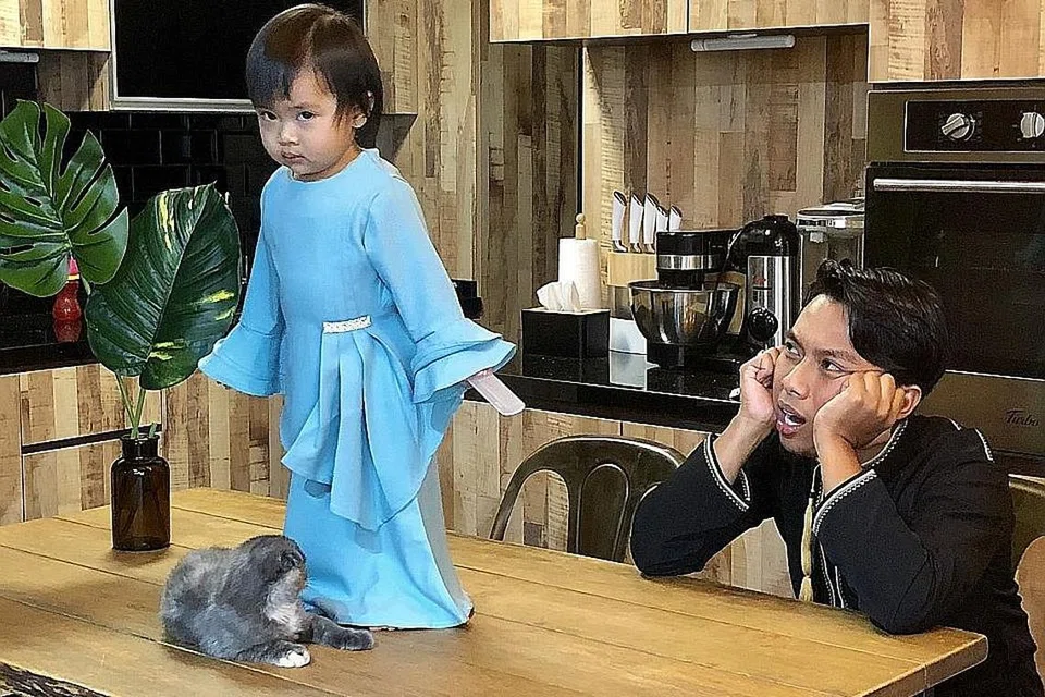 ANAK BAPAK: Pelawak Facebook dan YouTube, Syazwan Yunos (kanan), tidak menduga rakaman spontan dirinya bergurau senda dengan anaknya yang bersahaja, Aisyah Zuhairah, menarik perhatian ramai. Bersama mereka adalah kucing bernama Muezza yang juga bak 'pelakon tambahan' dalam setiap video Instagram mereka. - Foto BH oleh HARYANI ISMAIL