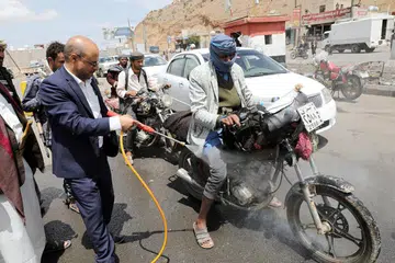 BASMI KUMAN: Seorang pegawai tempatan memancut cecair pembasmi kuman ke atas sebuah motosikal yang sedang ditunggang bagi membendung penularan koronavirus di pinggir kota Sanaa, Yemen, semalam. 