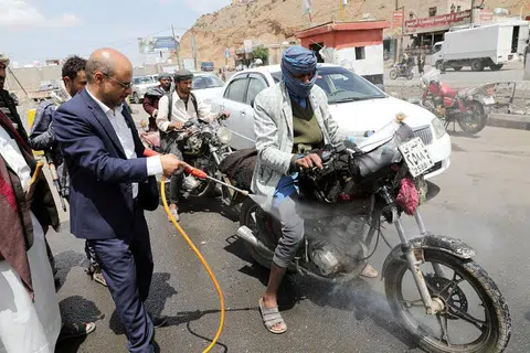 BASMI KUMAN: Seorang pegawai tempatan memancut cecair pembasmi kuman ke atas sebuah motosikal yang sedang ditunggang bagi membendung penularan koronavirus di pinggir kota Sanaa, Yemen, semalam. 