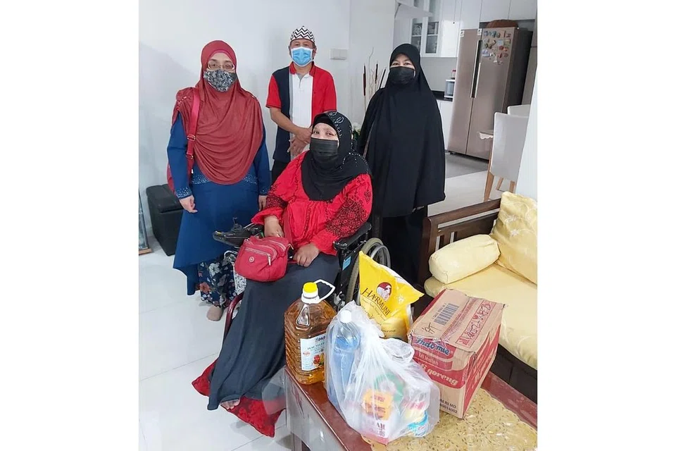 TETAP BERSYUKUR: Cik Mazidah Din (duduk, berkerusi roda) adalah penerima bantuan atau benefisari dari Pergeraq. Berdiri di belakang adalah ahli Jawatankuasa (AJK) persatuan tersebut (dari kanan) Cik Mariam Ajan, Encik Hashim Marsuni dan Cik Rozita Mohamed. Foto ini dirakam pada Ramadan tahun lalu. - Foto PERGERAQ