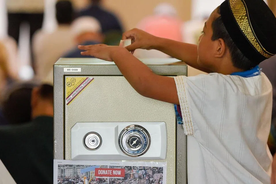 TURUT MENDERMA: Jemaah cilik di Masjid Al-Islah ini meletakkan sumbangan ikhlasnya ke dalam peti dana khas selepas menunaikan solat Jumaat semalam. - Foto BH oleh SYAZA NISRINA