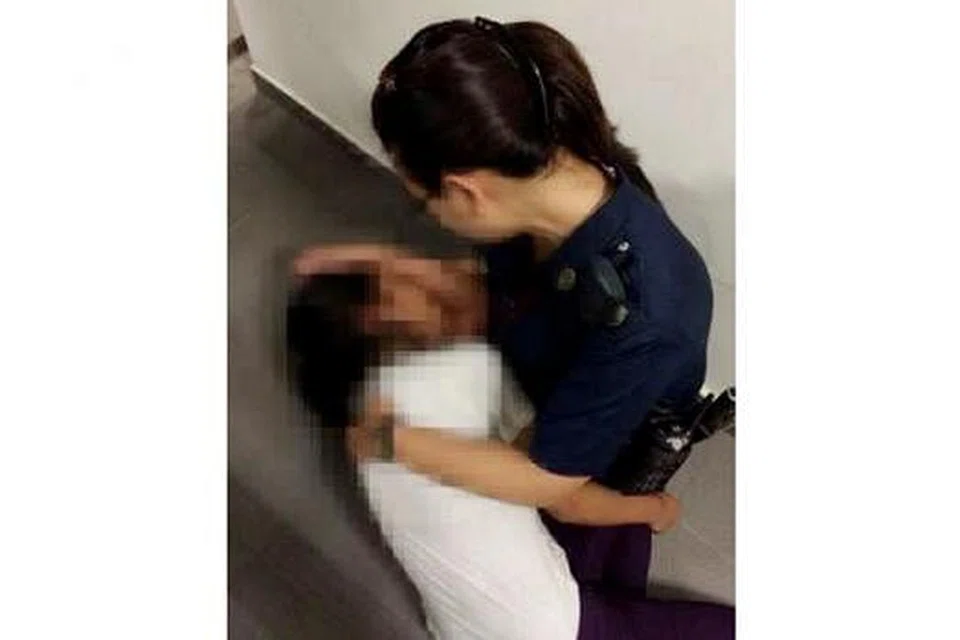 DAKAPAN PENUH KELEGAAN: Gambar ini, yang menunjukkan W/CPL Nur Fadhilah mendakap dan memujuk seorang remaja yang cuba bunuh diri, menerima lebih 3,000 'likes' dan dikongsi lebih 200 kali di Facebook. - Foto YISHUN NORTH NPC