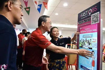 KIOS FASTJOBS: Cik Joelle Pang (kanan) menerangkan kepada Encik Sam Tan tentang kios FastJobs yang disediakan antaranya untuk warga emas di Radin Mas mencari pekerjaan sambilan dan sementara. - Foto BH oleh SONG TAO