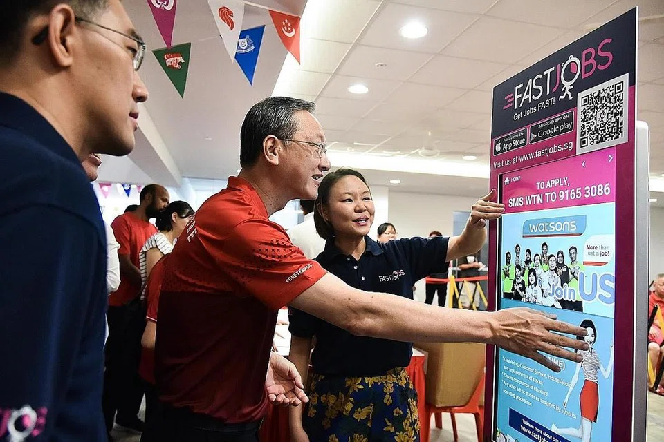 KIOS FASTJOBS: Cik Joelle Pang (kanan) menerangkan kepada Encik Sam Tan tentang kios FastJobs yang disediakan antaranya untuk warga emas di Radin Mas mencari pekerjaan sambilan dan sementara. - Foto BH oleh SONG TAO