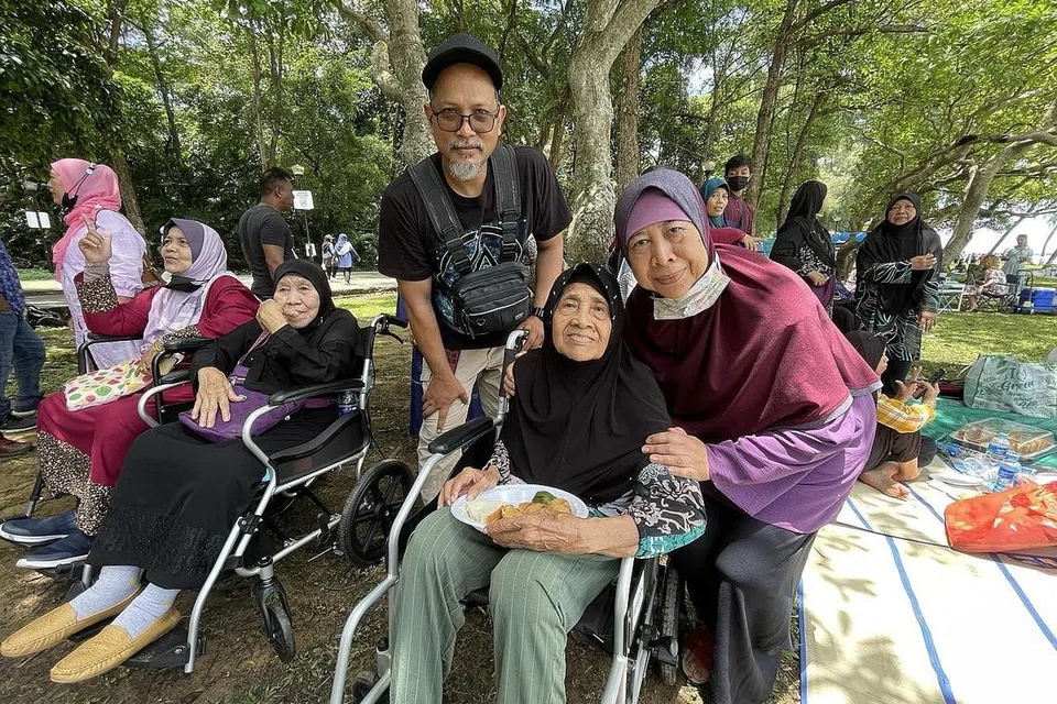 GEMBIRA DAPAT BERKUMPUL: Cik Chomail Senan (kanan, berkerusi roda) bersama anaknya Cik Intan Markom (kanan), serta cucu, Encik Razuli Koson (tengah). Mereka telah mengadakan perjumpaan bersama ahli keluarga lain dan penduduk Kampong Wak Kassim, Jalan Berseri pada hujung minggu lalu di Taman East Coast. 
