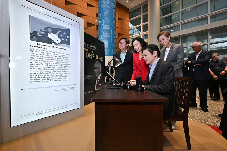 Perdana Menteri Lawrence Wong (duduk) merasmikan pembukaan dua pameran buku sembang interaktif prototaip, atau ChatBook, besar rekaan Lembaga Perpustakaan Negara (NLB) yang membolehkan pelawat mengetahui lebih lanjut tentang kehidupan dan sumbangan Encik Rajaratnam melalui respons yang dikuasakan AI Generatif. Beliau diiringi Menteri Penerangan dan Pembangunan Digital, Cik Josephine Teo (kanan); Ketua Pegawai Eksekutif (CEO) NLB, Encik Ng Cher Pong (kiri); dan penulis buku, Cik Irene Ng (berbaju merah).