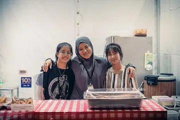 JAGA KEDAI: Pemilik perniagaan Ah Lim Nasi Lemak, Cik Aishah Lim (tengah), anak sulungnya Alisha Lim (kanan), 15 tahun dan Sarah Lim, 14 tahun, mengendali tempahan di gerai mereka di GastroBeats yang berlangsung hingga 26 Jun. - Foto BH oleh HARITH MUSTAFFA