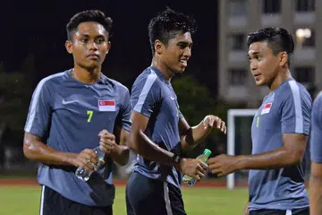 PIKUL HARAPAN NEGARA: Tiga pemain muda Singapura (dari kiri), Muhaimin Suhaimi, Ammirul Emmran dan Taufik Suparno, membasahkan tekak semasa sesi latihan menjelang pertemuan dengan Myanmar hari ini. - Foto FAKHRURADZI ISMAIL
