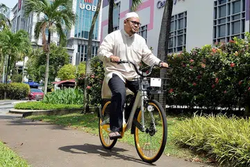 TIDAK SUSAH 'DAPATKAN' BASIKAL: Encik Mahathir mencuba basikal oBike, khidmat perkongsian basikal, buat pertama kali semalam. Beliau menaiki basikal itu dari rumahnya di Tampines ke pusat beli-belah Tampines Mall. - Foto ZAINAL YAHYA
