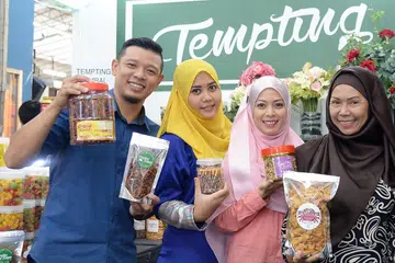 RATU HATIKU: Hady Mirza menanti Ramadan sebagai tempoh masa beliau dapat membangkitkan perniagaan kuih Raya dan air katira dengan bantuan (dari kanan) ibunya, Cik Mardiana Ahmad; kakaknya, Cik Adryany Amir; dan isterinya, Cik Nurjannah Nur Wahid. - Foto fail