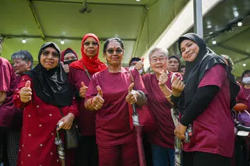 TURUN PADANG: Cik Hamidah Mohd Salleh (paling kanan) bersama penduduk Taman Jurong lain sanggup “turun padang” dari bahagian barat Singapura ke ibu pejabat Persatuan Rakyat di King’s George Avenue untuk melontarkan sokongan mereka bagi bakal calon presiden Encik Tharman Shanmugaratnam pada Selasa. 