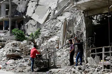 DIKUASAI TENTERA SEMULA: Rakyat Syria minum air dari sebuah pam di Douma, di pinggir Damsyik, kelmarin, semasa satu lawatan tersusun selepas tentera Syria mengisytiharkan semua pasukan antirejim telah meninggalkan Ghouta Timur. Amerika mendakwa Russia telah pergi ke tapak serangan kimia di bandar itu dan "mungkin telah mengusiknya" bagi menggagalkan usaha menyiasat serangan tersebut. Moscow menyifatkan tuduhan itu sebagai "pembohongan terang-terangan". - Foto AFP