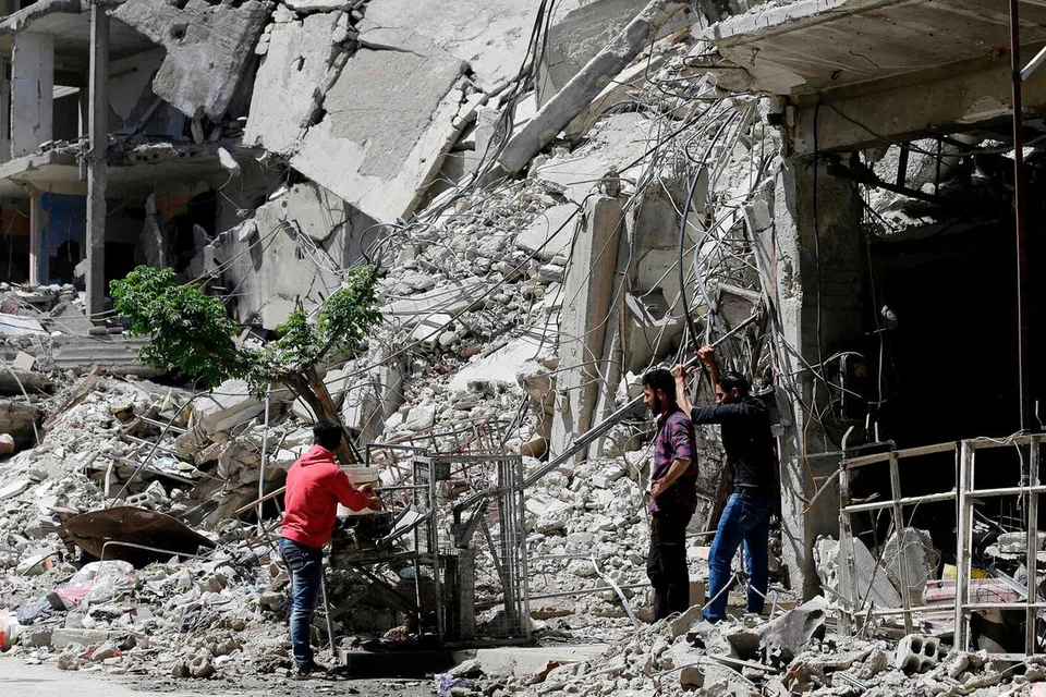 DIKUASAI TENTERA SEMULA: Rakyat Syria minum air dari sebuah pam di Douma, di pinggir Damsyik, kelmarin, semasa satu lawatan tersusun selepas tentera Syria mengisytiharkan semua pasukan antirejim telah meninggalkan Ghouta Timur. Amerika mendakwa Russia telah pergi ke tapak serangan kimia di bandar itu dan "mungkin telah mengusiknya" bagi menggagalkan usaha menyiasat serangan tersebut. Moscow menyifatkan tuduhan itu sebagai "pembohongan terang-terangan". - Foto AFP