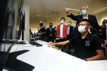 PANTAU TEKNOLOGI: Encik Teo Chee Hean (baris belakang, dua dari kanan) dan Menteri Perhubungan dan Penerangan, Cik Josephine Teo (tengah), melakukan lawatan ke pameran Kapal Permukaan Tanpa Pemandu di Sidang Puncak TechX diadakan di The Theatre at Mediacorp semalam. - Foto ZAOBAO