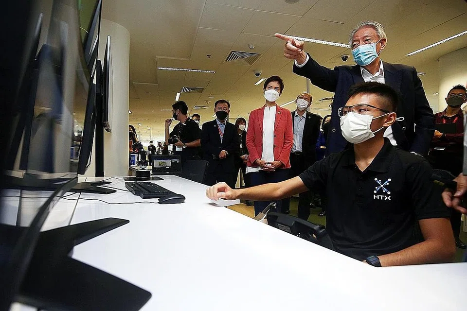 PANTAU TEKNOLOGI: Encik Teo Chee Hean (baris belakang, dua dari kanan) dan Menteri Perhubungan dan Penerangan, Cik Josephine Teo (tengah), melakukan lawatan ke pameran Kapal Permukaan Tanpa Pemandu di Sidang Puncak TechX diadakan di The Theatre at Mediacorp semalam. - Foto ZAOBAO