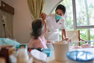 PENJAGAAN DI HUJUNG HAYAT: Seorang jururawat di Hospis Dover Park membantu pesakit menyikat rambutnya. Penjagaan paliatif ditawarkan oleh pelbagai penyedia khidmat di Singapura, seperti hospis, hospital masyarakat, hospital awam dan rumah penjagaan warga emas. 