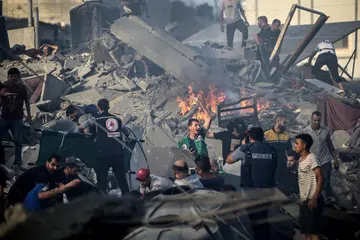 RUNTUH: Orang ramai mencari mangsa yang mungkin masih hidup di bawah bangunan yang runtuh ekoran serangan udara Israel di Gaza pada Rabu. 