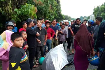 Orang ramai melihat mangsa yang meninggal dunia selepas dihempap sebatang pokok tumbang dalam kejadian ribut di Kampung Petani, Sering dekat Bachok, Kelantan, pada petang 15 Julai.