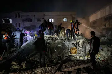 SERUAN GENCATAN SEMAKIN MENINGKAT: Para anggota bomba dan penduduk berganding bahu mencari mangsa dalam runtuhan bangunan ekoran pengeboman Israel di Rafah, selatan Gaza, pada 18 Disember.