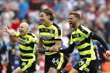 GEMBIRA SEKALI: Pemain-pemain Huddersfield - (dari kiri) Aaron Mooy, Michael Hefele dan Martin Cranie - meraikan kejayaan pasukan itu mendapat tempat dalam Liga Perdana musim depan. - Foto REUTERS