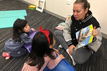 TINGKAT KECELIKAN MEMBACA: Cik Shahidah sedang mengajar beberapa pelajarnya membaca di pusat mereka di Australia. - Foto AIMSPARKE PTY LTD