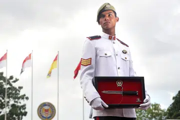 KERJA KERAS BERBALOI: Atas kerja keras dan menunjukkan kecekalan dalam menjalani latihan, 3SG turut dianugerahkan Bayonet Perak sewaktu upacara perbarisan tamat latihan. - Foto BH oleh KELVIN CHNG