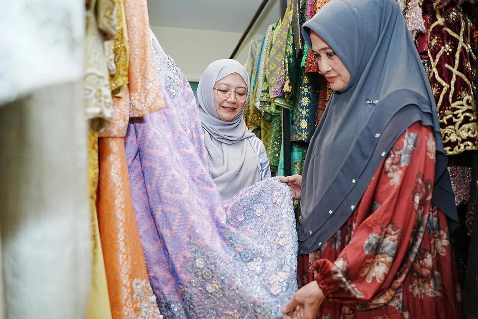 Cik Masturah Abdullah (kanan), pemilik perkhidmatan pengantin, Putri Mas Bridal, adalah antara mak andam tertua di Singapura yang bertahan dalam perniagaan perancangan perkahwinan selama lebih tiga dekad. Beliau kini menyokong usaha menantunya, Cik Siti Aisha Salim (kiri), meneruskan perniagaan perkahwinan yang dikenali sebagai Qawin by Putri Mas, beroperasi di Bright Centre, Telok Kurau Lorong L.