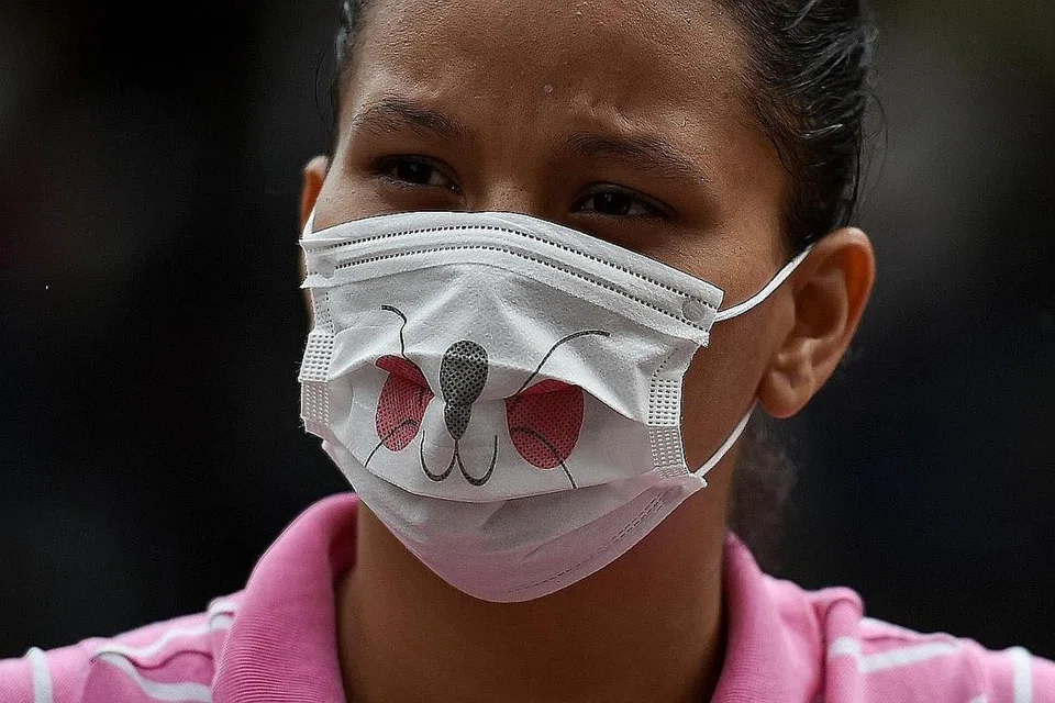 COLUMBIA: Penghijrah di Colombia ini memakai pelitup sementara menanti untuk menaiki bas. - Foto AFP 