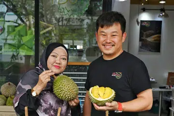 Cik Siti Noranini Mohd Yajib dan pemilik ‘The Durian Story’, Encik Jonathan Tee mengenali satu sama lain sejak lima tahun lalu tetapi ini kali pertama Cik Siti membantunya sebagai penjual durian.