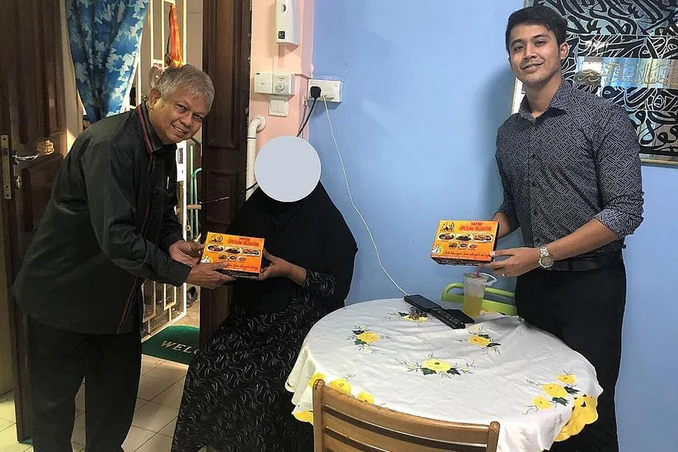 DEKATI MASYARAKAT: Alif Aziz (paling kanan) dan Husin Saaban mengunjungi kediaman salah seorang benefisiari Jamiyah. Aliff kini bekerja sepenuh masa dengan Jamiyah Singapura sebagai pegawai di jabatan pembangunan dan perhubungan masyarakat. - Foto JAMIYAH SINGAPURA