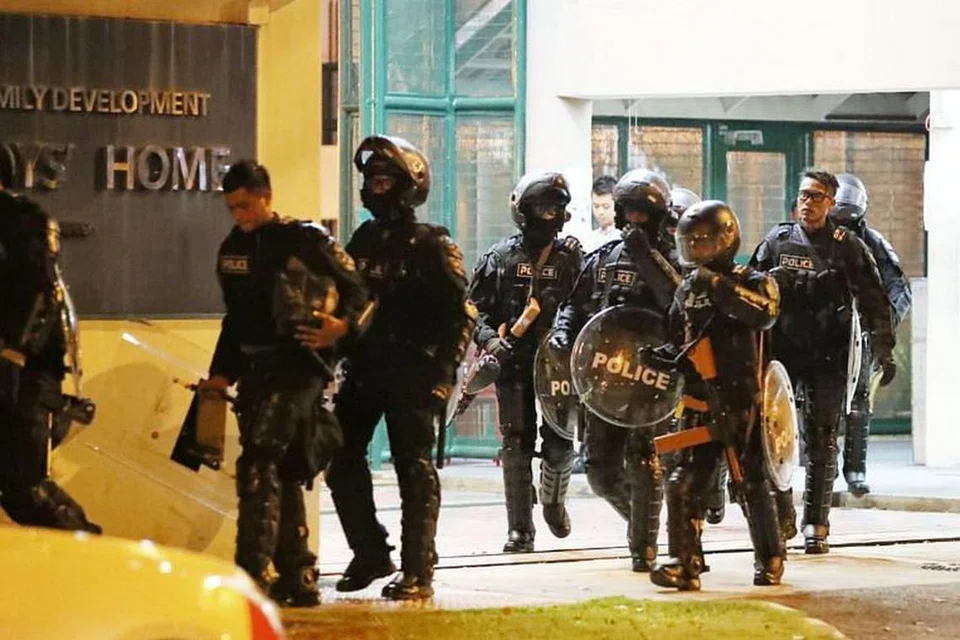 Pegawai polis berkelengkapan pakaian rusuhan keluar dari Singapore Boys' Home di Jurong West pada Jumaat (28 Sep) petang. Dua kakitangan lelaki rumah tersebut dan seorang pegawai polis bantuan dihantar ke Hospital Ng Teng Fong kerana mengalami kecederaan ringan. 