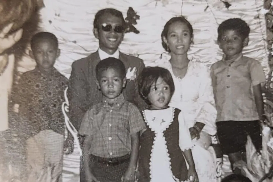 Encik Yusof Tisari (barisan depan, kiri), yang hanya berusia 5 tahun, di majlis perkahwinan kakaknya, Cik Sukina Gimon (barisan belakang, dua dari kanan), di Pulau Semakau.