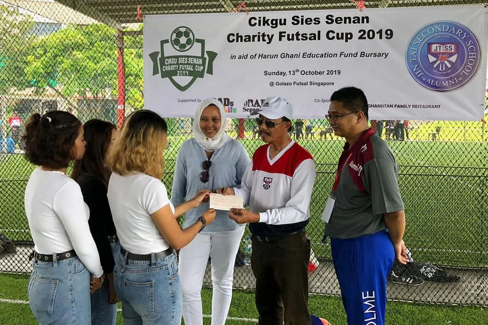 DEMI PENDIDIKAN: Cikgu Sies Senan (dua dari kanan) menyampaikan cek $1,200 kepada 'Cik Masturah' bagi pihak HGEF, semasa Piala Futsal Amal Cikgu Sies Senan. Bersamanya ialah Cik Haslinda Putri Harun dan Encik Iskandar Wachi. - Foto HGEF