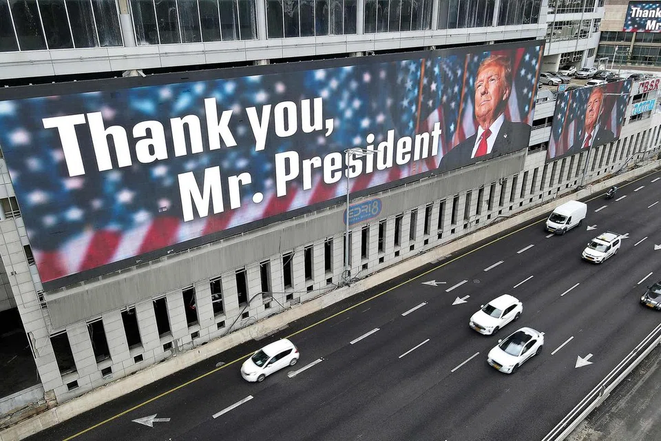Sebuah papan iklan yang memaparkan potret Presiden Amerika Syarikat, Encik Donald Trump, bersama slogan, dipamerkan pada sebuah bangunan hotel di Tel Aviv, pada 5 Februari.  