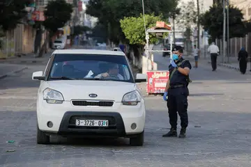 PERINTAH SEKATAN: Seorang pegawai keselamatan Palestin memeriksa sebuah kereta semasa menguatkuasakan perintah berkurung selama 48 jam di Jaluran Gaza berikutan penemuan kes jangkitan tempatan Covid-19. - Foto AFP