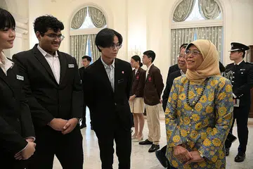SUMBANGAN BELIA: Presiden Halimah berinteraksi dengan Pejuang Keharmonian yang baru dilantik di bawah program Pejuang Keharmonian Yayasan Temasek-Roses of Peace, (dari kiri) Cik Cheryln Yang, Encik Vickneswaran Somu Thevar Ramadoss dan Encik Blaise Kwok dari Politeknik Nanyang di Istana. - Foto ST