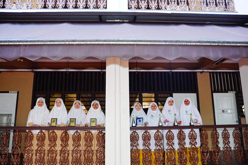 Madrasah Alsagoff al-Arabiah envió dos equipos. El equipo A incluye (desde la izquierda) Umamah Zakaria, Aisha Abdul Akber, Nur Hijanah Mohamed Hisham y Nurul Afifah Ahmad. Equipo B (de la derecha) Haneen Hasmuraizah, Maryam Kautsar Fadhlur Rahman, Wereyka Nawfah Mas'udin y Alisha Nuha Muhammad Iqbal.
