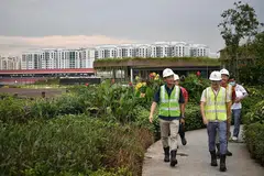 PANTAU KEMAJUAN: Encik Ong (kiri) dan para penasihat GRC Sembawang berpeluang melihat secara dekat perkembangan terkini hab sukan dan masyarakat bersepadu yang dikenal sebagai Bukit Canberra semalam. - Foto BH oleh ARIFFIN JAMAR