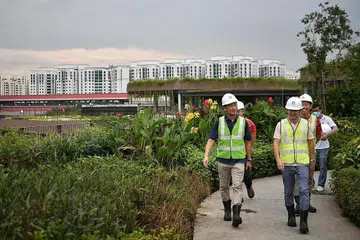PANTAU KEMAJUAN: Encik Ong (kiri) dan para penasihat GRC Sembawang berpeluang melihat secara dekat perkembangan terkini hab sukan dan masyarakat bersepadu yang dikenal sebagai Bukit Canberra semalam. - Foto BH oleh ARIFFIN JAMAR