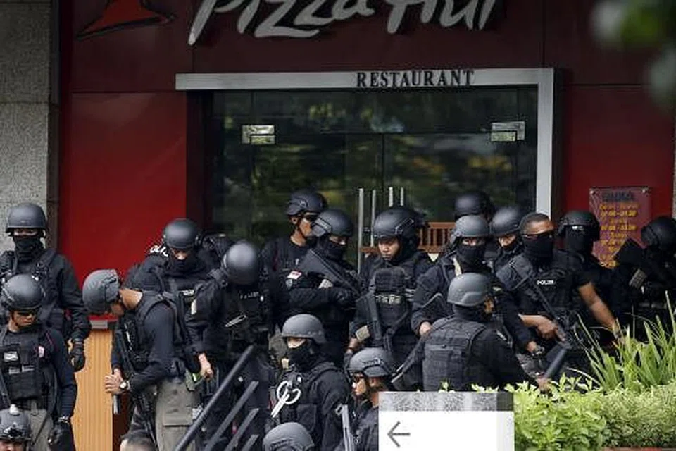 Pasukan poils berkumpul di luar sebuah restoran dekat kawasan serangan bom di pusat Jakarta. - Gambar Reuters