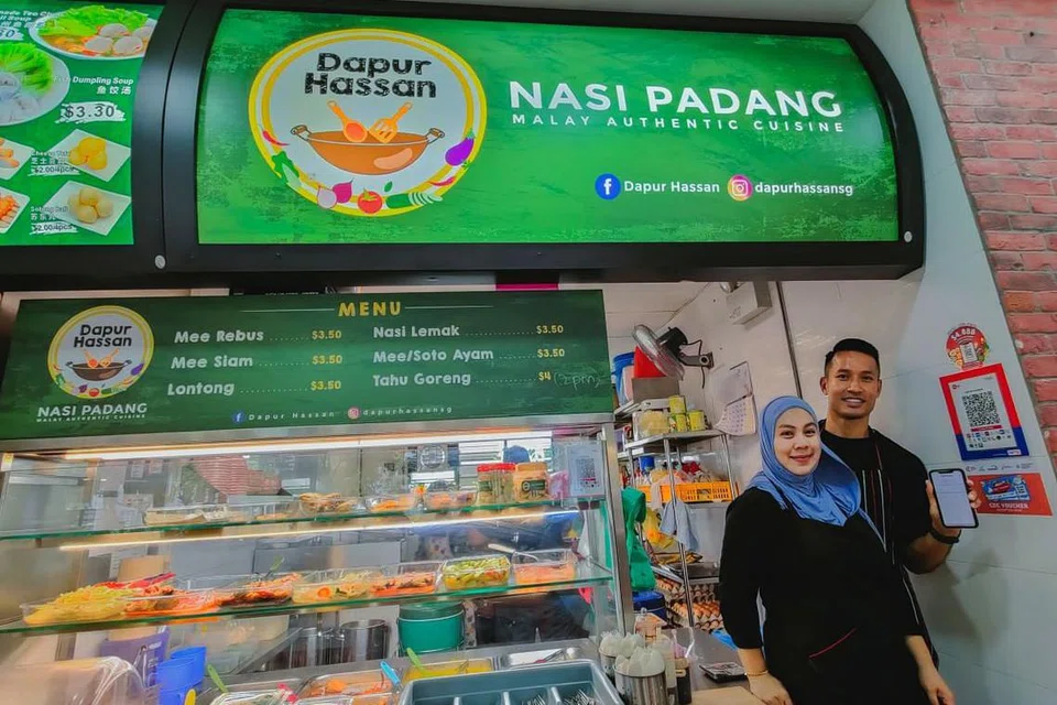 WADAH BARU: Cik Noraidah Abdul Rahim, dan suaminya pemain bola sepak negara, Encik Hassan Sunny, memanfaatkan wadah e-pembayaran bagi gerai nasi padang mereka yang dibuka Oktober tahun lalu.
