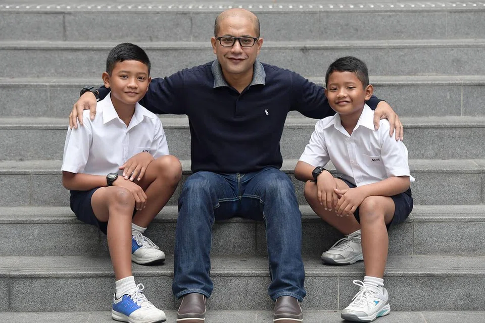 BERCITA-CITA BESAR: Muhammad Raihan (kiri) dan Muhammad Razin (kanan), bergambar dengan bapa mereka, Encik Mohd Airudin. - Foto THE STRAITS TIMES